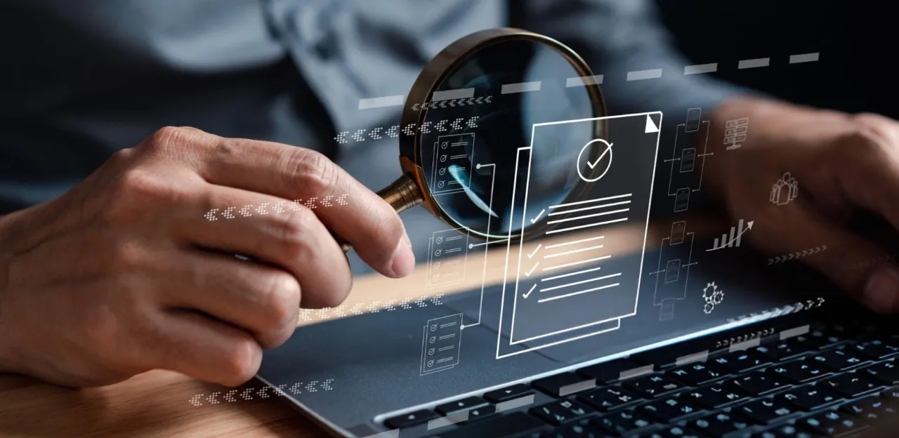 A magnifying glass over a financial spreadsheet, symbolizing data-driven auditing.
